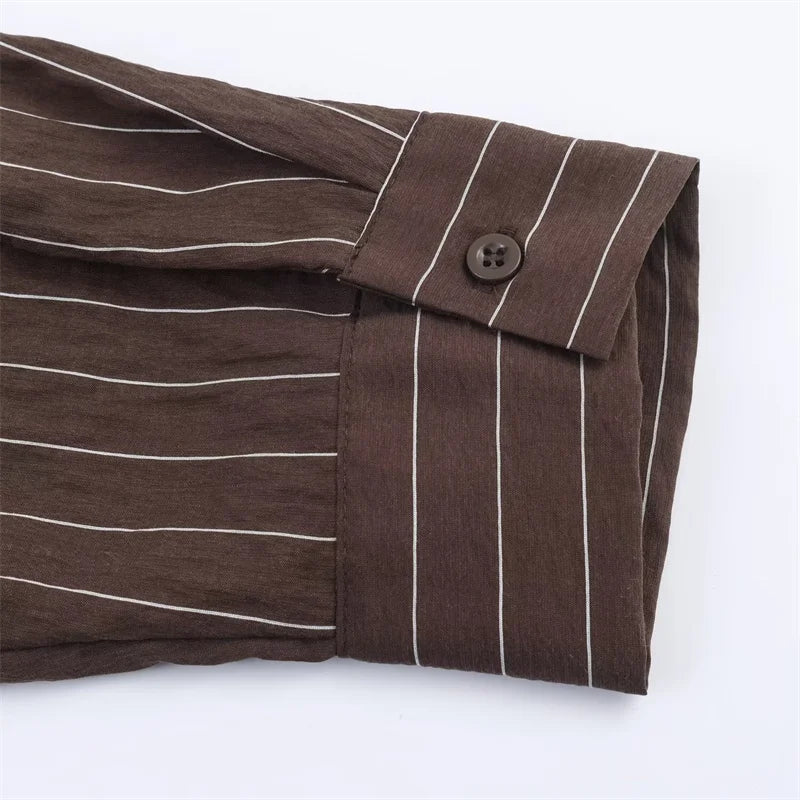 A women’s brown shirt in the “old money” aesthetic embodies quiet luxury and understated refinement. Typically crafted from high-quality fabrics like silk, fine cotton, or linen, it features a clean, tailored silhouette