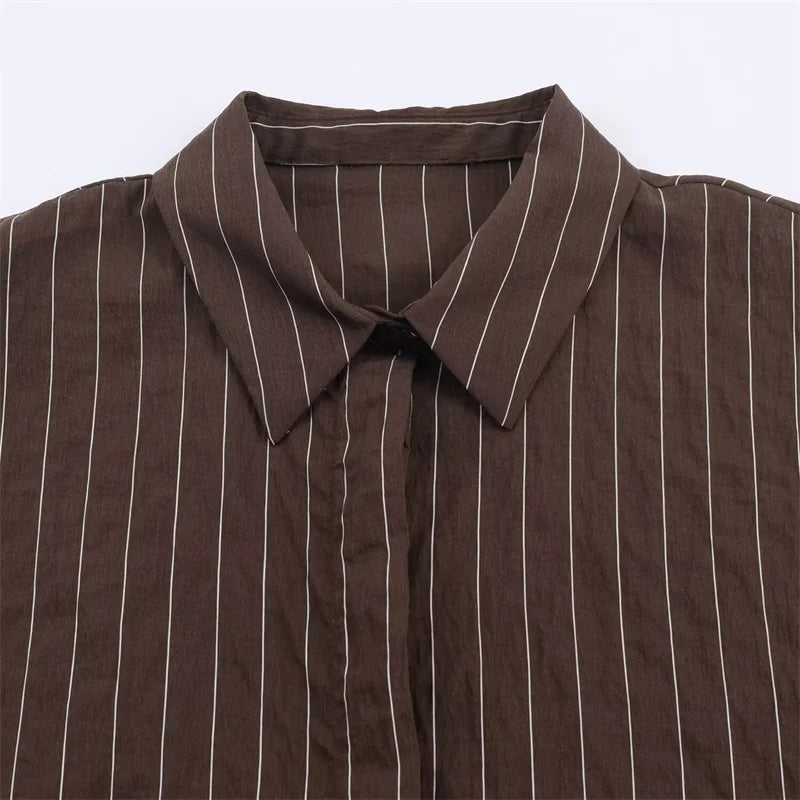 A women’s brown shirt in the “old money” aesthetic embodies quiet luxury and understated refinement. Typically crafted from high-quality fabrics like silk, fine cotton, or linen, it features a clean, tailored silhouette