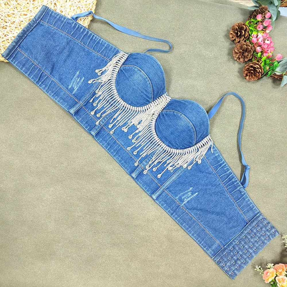 A denim corset with hanging rhinestones strikes a bold balance between rugged edge and high-glam allure. The structured denim hugs the body, giving it that classic, sculpted silhouette, while the cascading rhinestones add mov