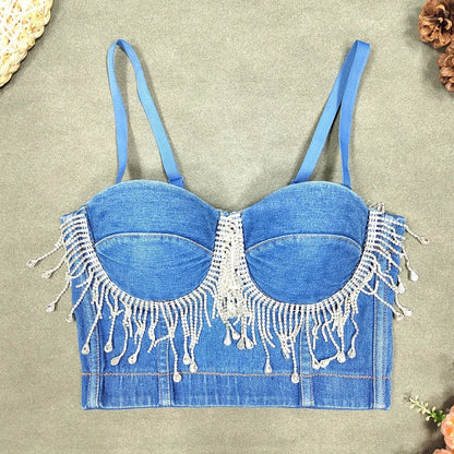 A denim corset with hanging rhinestones strikes a bold balance between rugged edge and high-glam allure. The structured denim hugs the body, giving it that classic, sculpted silhouette, while the cascading rhinestones add mov