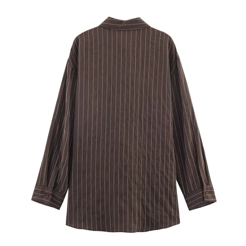 A women’s brown shirt in the “old money” aesthetic embodies quiet luxury and understated refinement. Typically crafted from high-quality fabrics like silk, fine cotton, or linen, it features a clean, tailored silhouette
