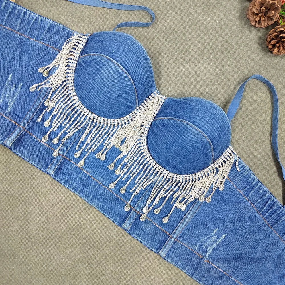 A denim corset with hanging rhinestones strikes a bold balance between rugged edge and high-glam allure. The structured denim hugs the body, giving it that classic, sculpted silhouette, while the cascading rhinestones add mov