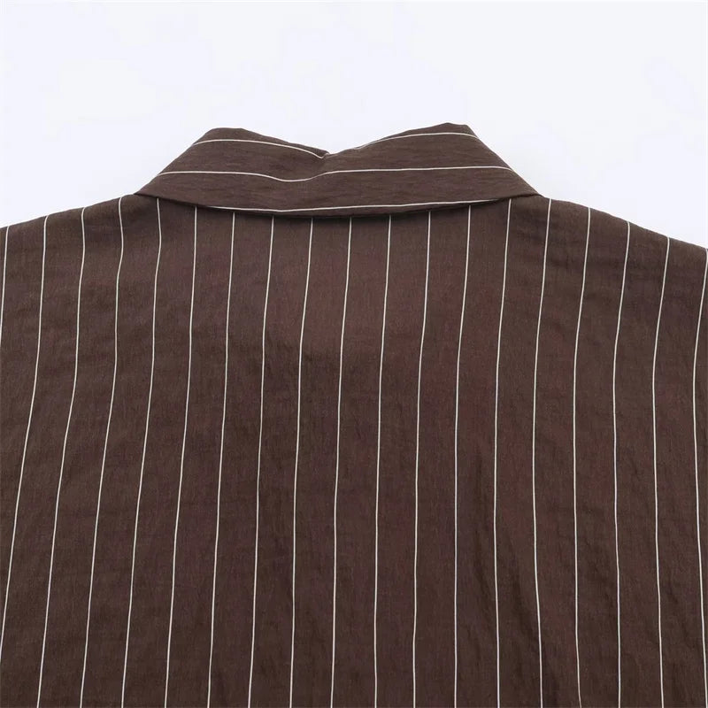 A women’s brown shirt in the “old money” aesthetic embodies quiet luxury and understated refinement. Typically crafted from high-quality fabrics like silk, fine cotton, or linen, it features a clean, tailored silhouette