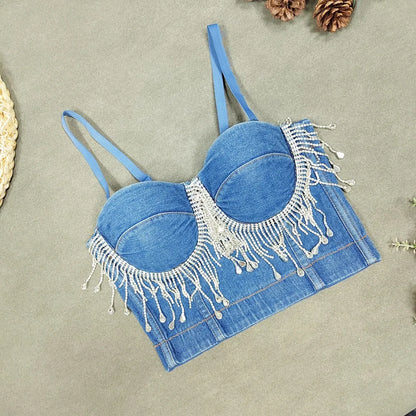 A denim corset with hanging rhinestones strikes a bold balance between rugged edge and high-glam allure. The structured denim hugs the body, giving it that classic, sculpted silhouette, while the cascading rhinestones add mov